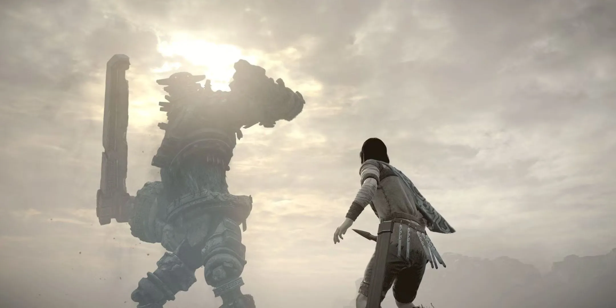 Nhân vật Wander trong Shadow of the Colossus ngước nhìn một Colossus khổng lồ với thanh kiếm sẵn sàng.