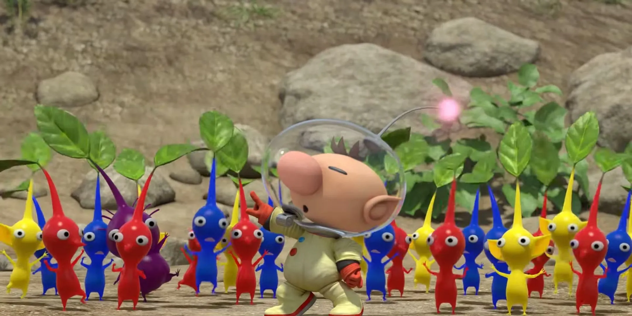 Olimar đang chỉ huy một nhóm Pikmin đủ màu sắc đỏ, xanh, vàng và tím.