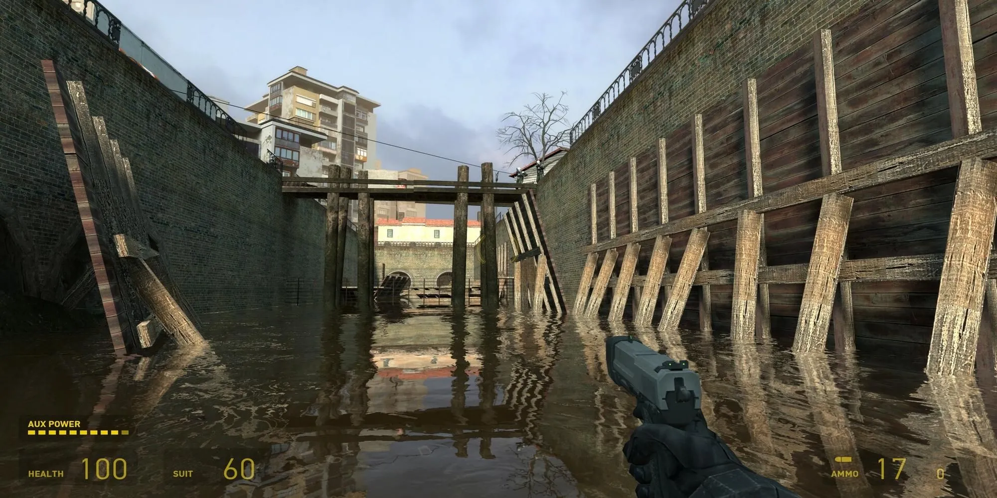 Gordon Freeman lội qua vùng nước ngập trong Half-Life 2, cầm khẩu súng lục, khám phá thế giới đổ nát của City 17