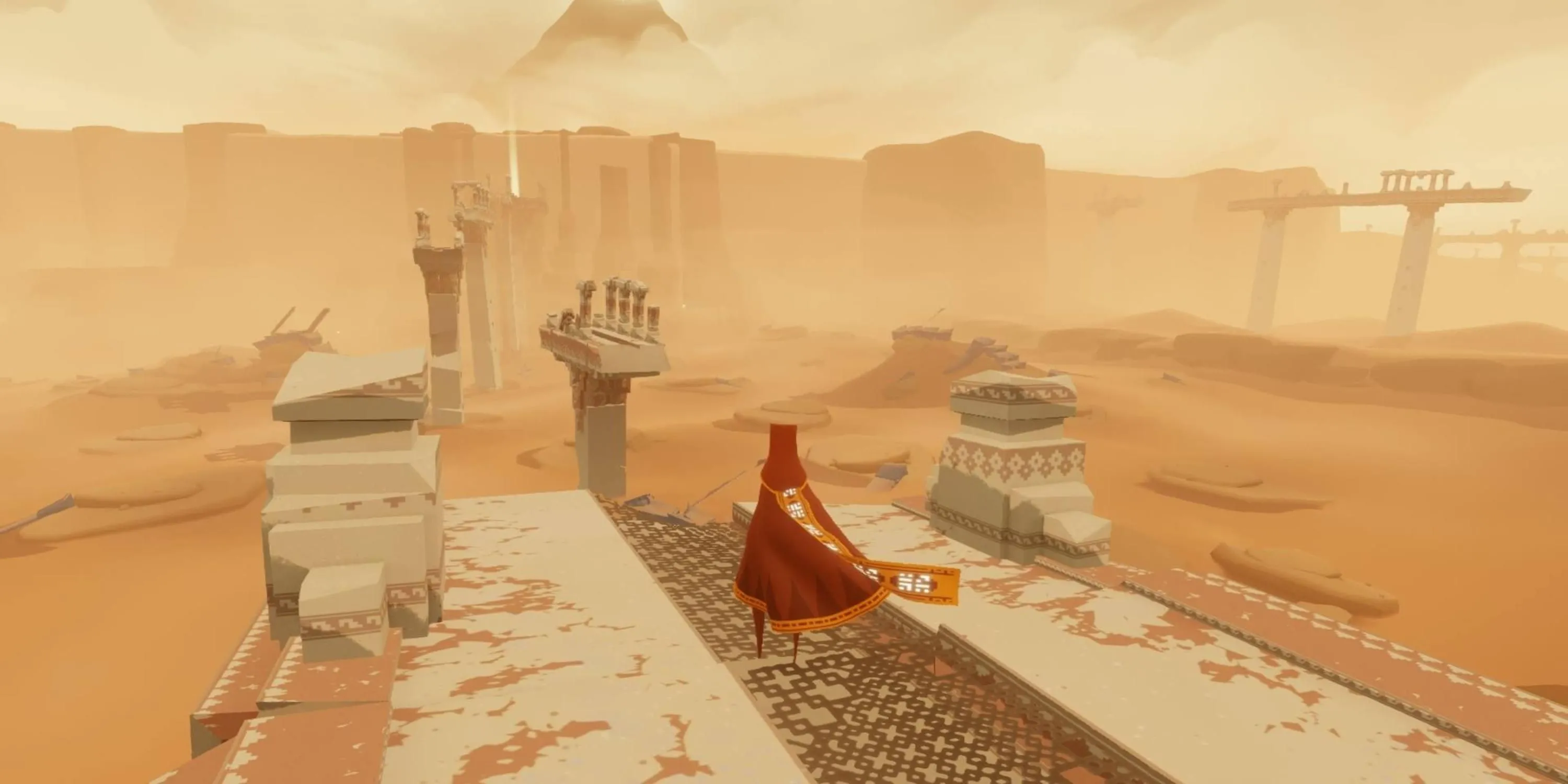 Nhân vật áo choàng đỏ đứng giữa sa mạc huyền bí nhìn về phía ngọn núi xa xăm trong game Journey