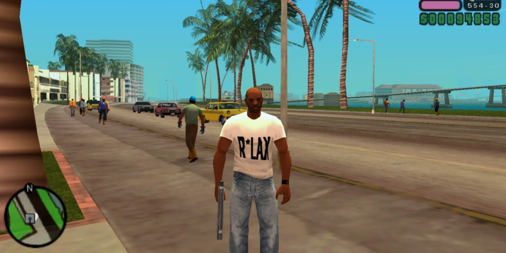 Victor Vance cầm súng đứng trên bãi biển ở Vice City Stories